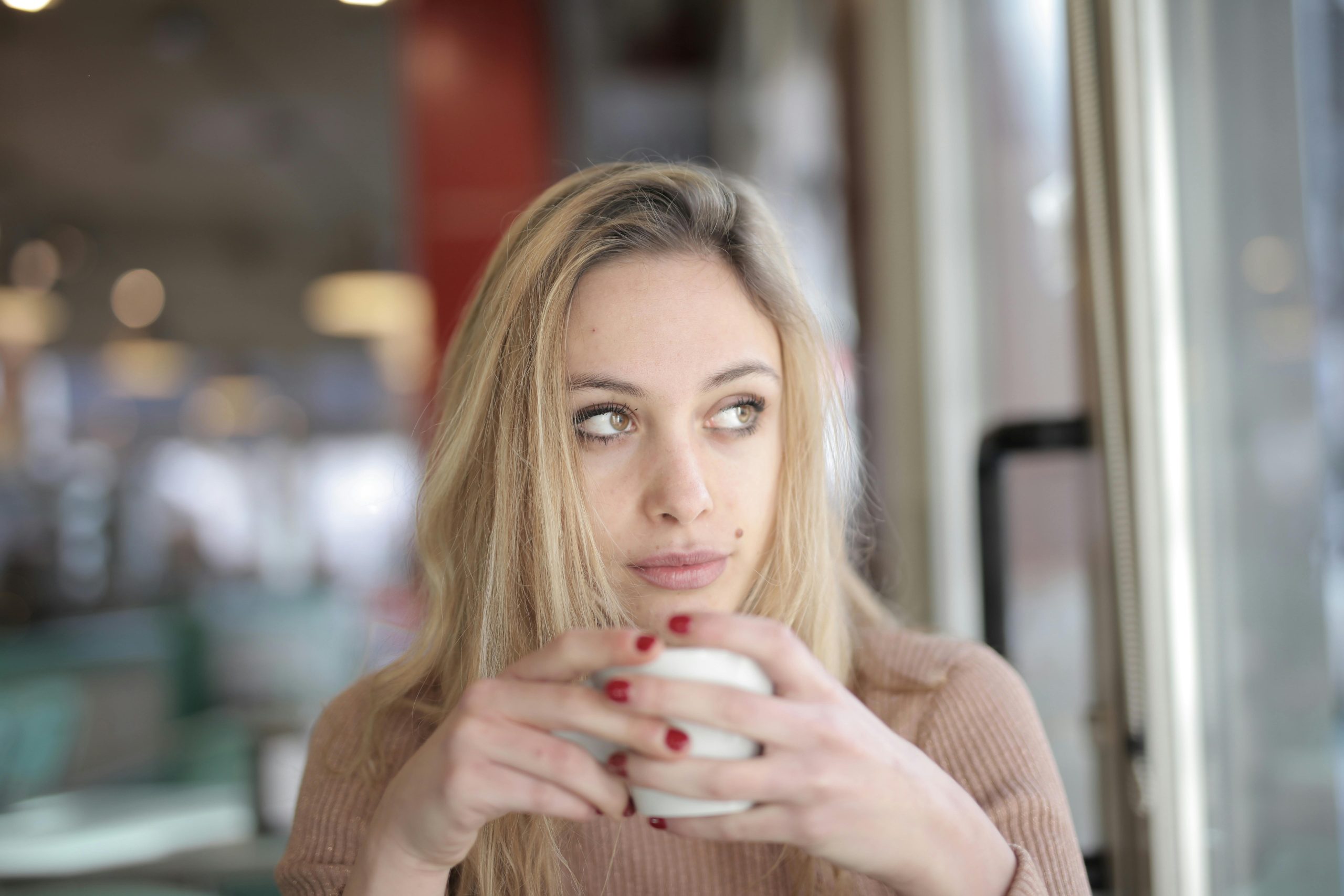 White woman drinking coffee and thinking